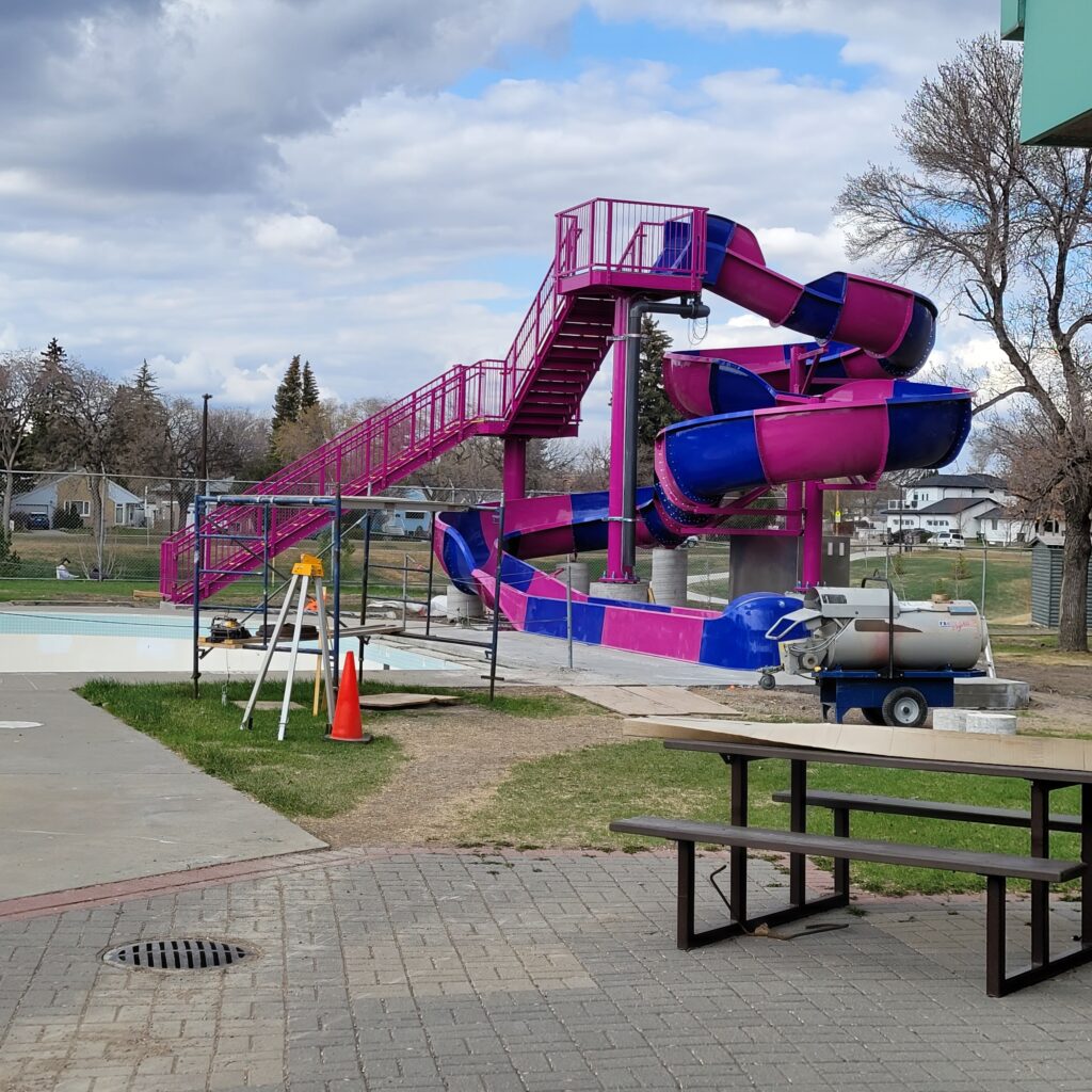 New blue and purple slide at Lathey Pool with construction equipment in front of it